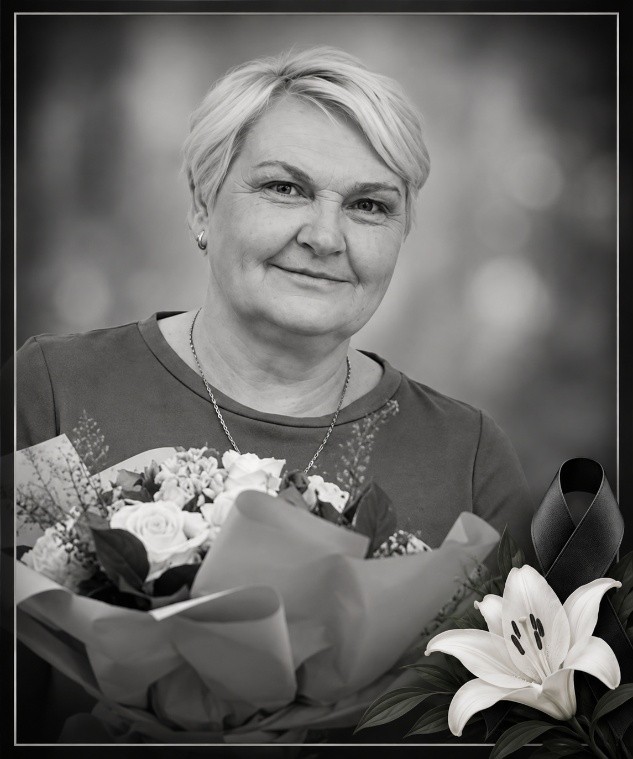 Czarno-białe djęcie przedstawiające Małgorzatę Janik z bukietami kwiatów i żałobną wstęgą w prawym dolnym rogu